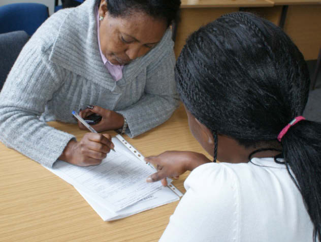 Woman helping a refugee fill in a form